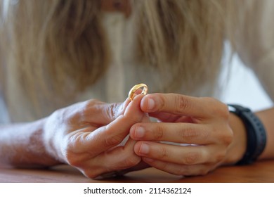 Woman's Hands Holding A Golden Wedding Ring.