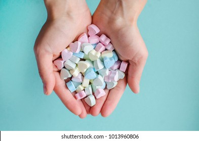 Woman's Hands Holding Heart Candy On Blue Background