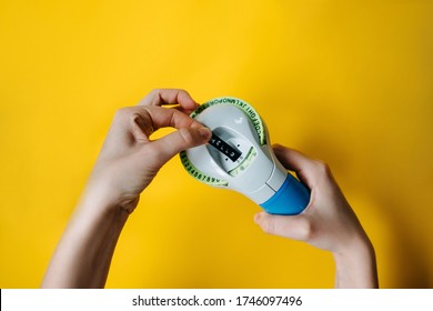 Woman's Hands Holding A Label Maker With Hello Word Typed, On Bright Yellow Background.