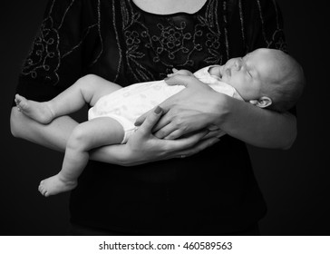 Woman's Hands Holding A Newborn Baby, Black And White