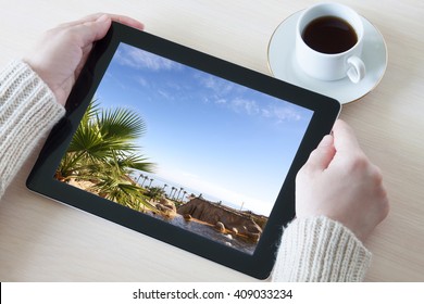 Woman's Hands Holding Tablet Pc With Sea View Wallpaper, At The Desk With A Cup Of Coffee