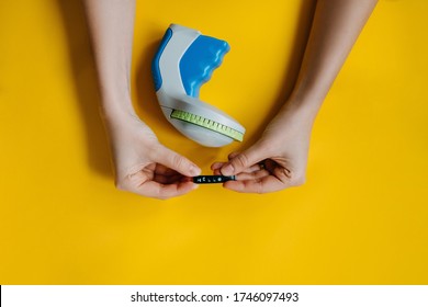 Woman's Hands Holding A Tape With Hello Word Typed With A Label Maker, On Bright Yellow Background.