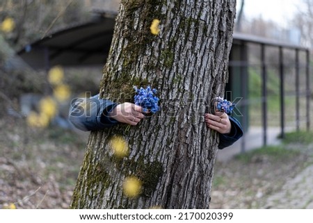 Woman's hands hugging a tree