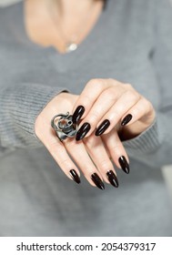 Woman's hands and long nails   black manicure and bottles nail polish