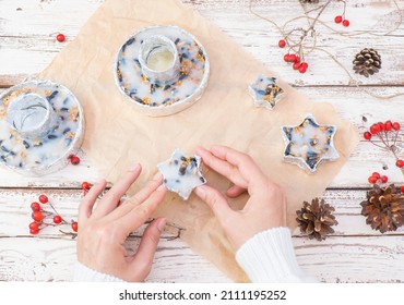 The Woman's Hands Make Food For Wild Birds From Lard And Seeds, Millet, In Foil Molds. Winter Bird Feeder On A White Wooden Background. View From Above