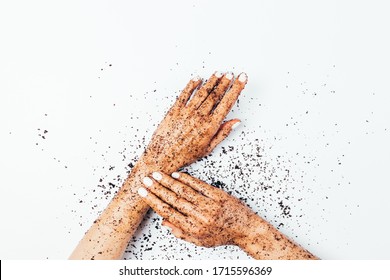 Woman's Hands Making Exfoliating Procedure Applying Coffee Body Scrub On White Background, Flat Lay.