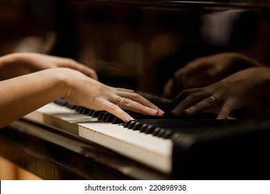 Woman's Hands On The Keyboard Of The Piano Closeup