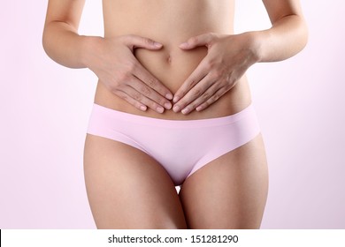 Woman's hands on stomach on white background