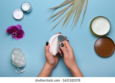 Woman's Hands Are Opening New Jar Of Cream On Blue Background With Cosmetic Products Jars Flat Lay