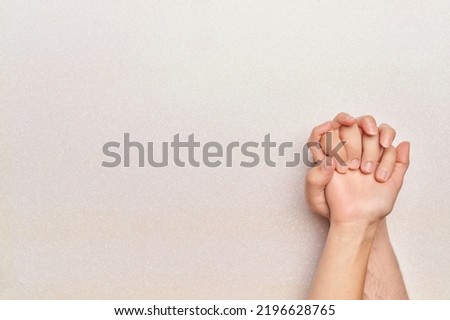 woman's hands over man's hands on bright white background copy space