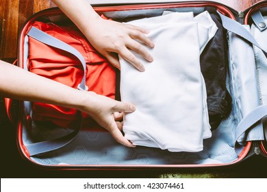 Woman's Hands Are Packing A Luggage