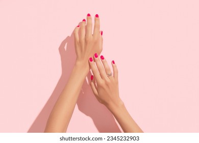 Womans hands with pink nail design. Manicure, pedicure beauty salon concept. Deep long shadows.