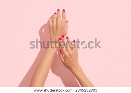 Womans hands with pink nail design. Manicure, pedicure beauty salon concept. Deep long shadows. 商業照片 © 