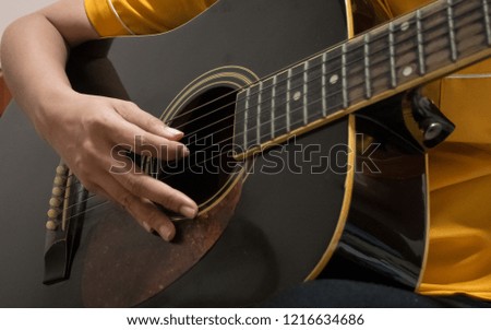 Woman's hands playing acoustic guitar.