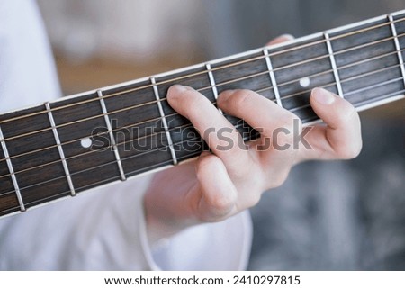 woman's hands playing the acoustic guitar, close up. Fingerpicking, fret, guitar neck