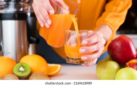 Woman's Hands Pour Freshly Prepared Tasty And Healthy Juice Into A Glass. Healthy Fruit Juices At Home. Close-up. Selective Focus.