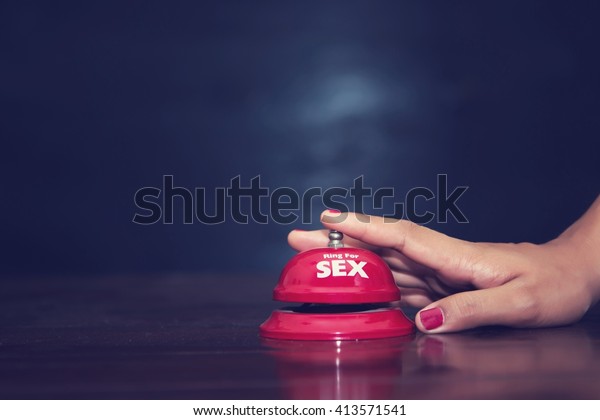 woman\'s hands press sex bell on a reception\
bell. concept about sex and\
eroticism