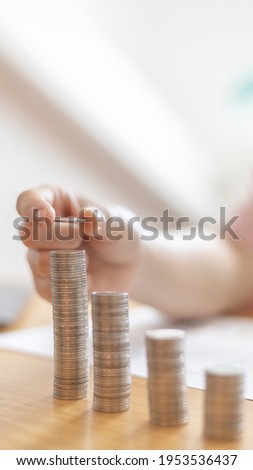 Woman's hands put the coins arranged in steps, Managing your finances or saving money for future use, Saving for investment, Saving money for business growth or long-term profitability.