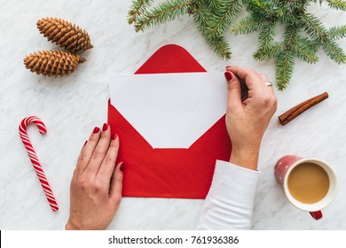 Woman's hands putting blank paper in red envelope, Christmas concept - Powered by Shutterstock