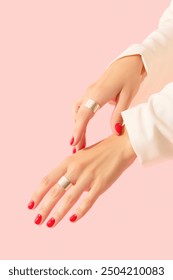 Womans hands with red manicure on pink background. Beauty salon concept