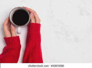 Woman's Hands In A Red Sweater Holding A Cup Of Coffee, Top View