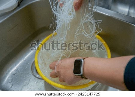 Woman's hands separating rice noodles
