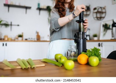 A Woman's Hands Squeeze Celery Juice With A Juicer