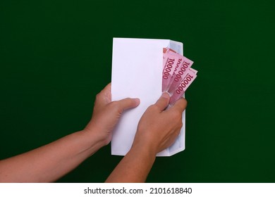 A Woman's Hands Takes Out Some Money From A White Envelope.