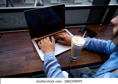 Woman's hands typing on laptop. Remote work concept. Cozy coffeehouse atmosphere. Focus on modern gray laptop. Cup of tasty latte. Smart casual style. - Powered by Shutterstock