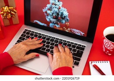 Woman's Hands Typing On Laptop Keyboard  At Christmas Time - Red Background With Christmas Presents