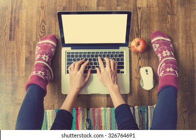 Woman's Hands Typing On Laptop Keyboard. Study And Work Online, Freelance, Warm Socks, Winter, Home Comfort And Relax