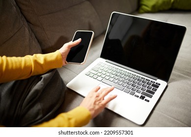 Woman's hands using phone and laptop making online order, checking purchase, shopping at home, indoors. Concept of startup, small business. Entrepreneur owner. Black Friday or cyber Monday - Powered by Shutterstock