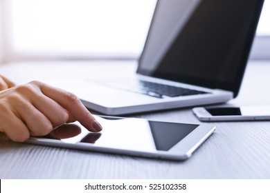 Woman's hands using tablet pc and laptop at the office