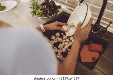 A woman's hands wash mushrooms before cooking a dish against the background of the kitchen sink - Powered by Shutterstock