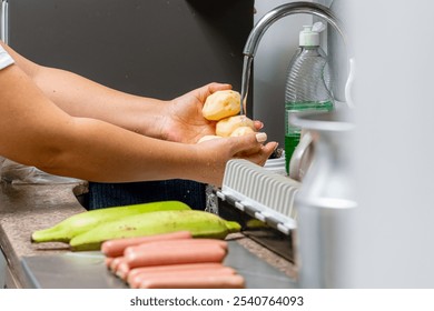 Woman's hands washing potatoes in her kitchen. Latin mother cooking for her family. Easy to make food. - Powered by Shutterstock