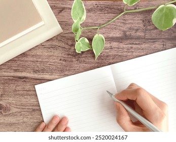 A woman's hands writing in a notebook