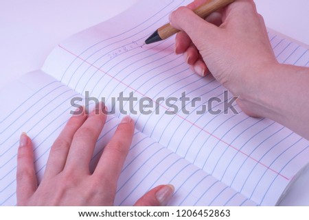 Woman's hands Writing in Open Composition  Notebook, Wide Ruled (ruler).  