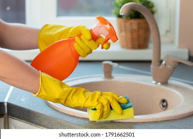 Woman's Hands In Yellow Gloves Cleaning Counter Top In Kitchen