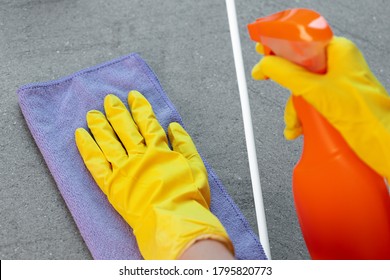 Woman's Hands In Yellow Gloves Cleaning Counter Top In Kitchen