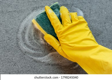 Woman's Hands In Yellow Gloves Cleaning Counter Top In Kitchen