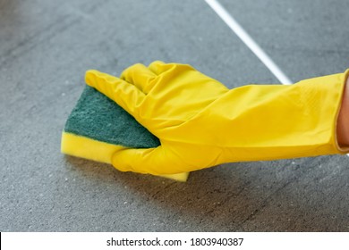 Woman's Hands In Yellow Gloves Cleaning Counter Top In Kitchen