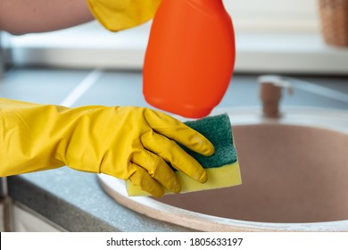 Woman's Hands In Yellow Gloves Cleaning Counter Top In Kitchen