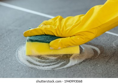 Woman's Hands In Yellow Gloves Cleaning Counter Top In Kitchen