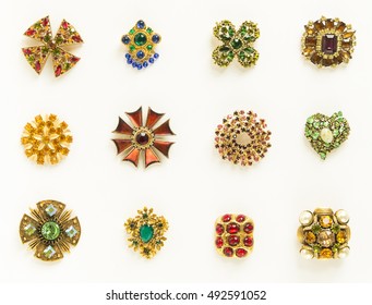 Woman's  Jewelry. Old vintage brooches. Beautiful bright rhinestones brooches on white. Not isolated. Flat lay, top view