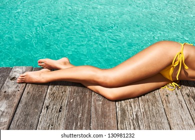 Woman's Legs At Beach Jetty