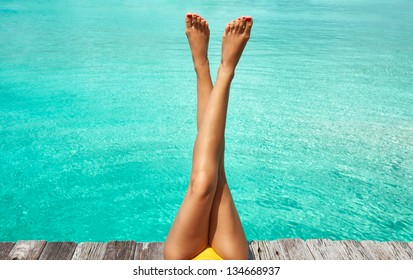 Woman's Legs At Beach Jetty