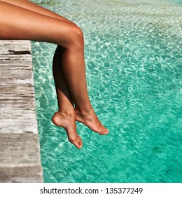 Woman's Legs At Beach Jetty