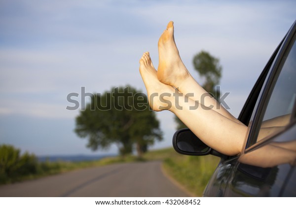 Woman\'s legs out of car\
windows.Freedom, travel and vacation road trip concept lifestyle\
image.