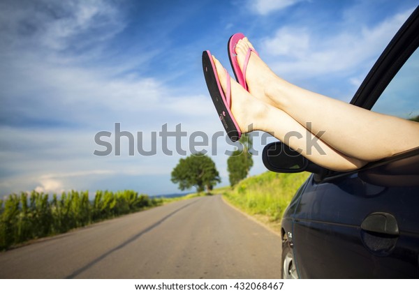 Woman\'s legs out of car\
windows.Freedom, travel and vacation road trip concept lifestyle\
image.