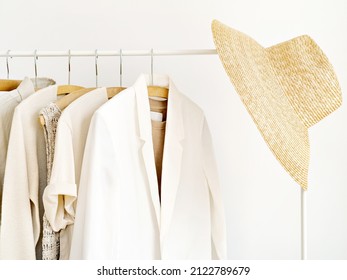 Woman's Linen And Cotton Wardrobe In Shades Of Beige On White. Rack With Spring Summer Female Clothes On Hangers Next To Wall. Clothing Retails Concept. Advertise, Sale, Fashion. Simplicity Concept.